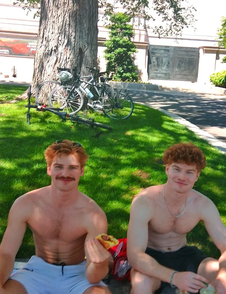 Rowan Frew sitting on the grass with a friend