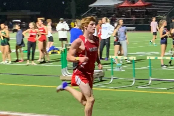 Rowan Frew sprinting on a track at night